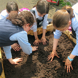 girls planting in a raised bed